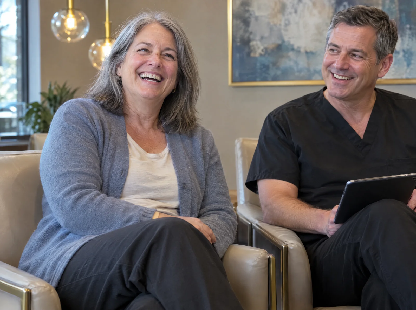 Patient laughing during a relaxed consultation in a dental office lounge